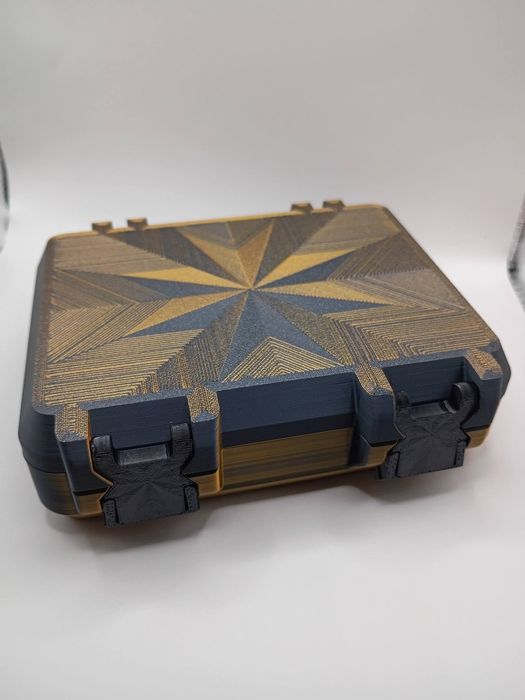 Closed hard case with a gold and black starburst lid and front latches