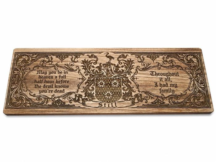 Engraved wood plaque with a heraldic crest, the Still family banner, and two inscriptions