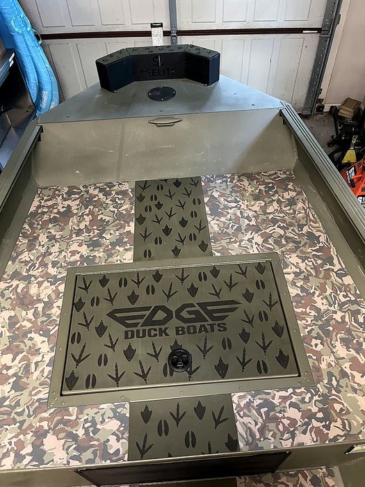Hatch lid engraved with the Edge Duck Boats logo surrounded by duck and deer tracks