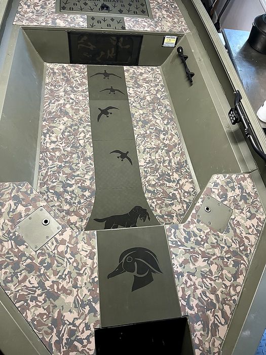 Close view of the engraved retriever carrying a duck and the wood duck head panel