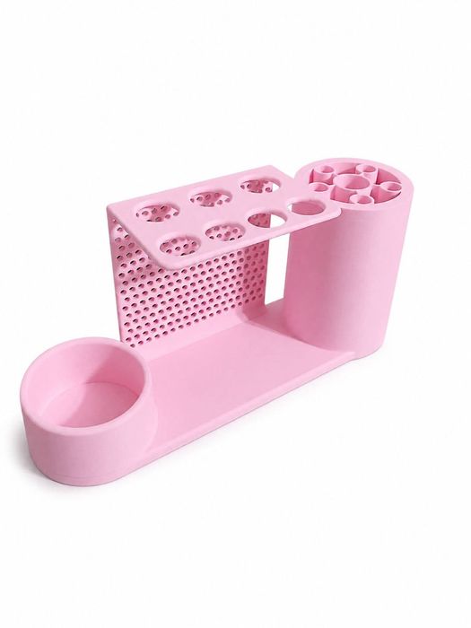Pink organizer with a round pill bottle cradle, perforated syringe holder, and center rack
